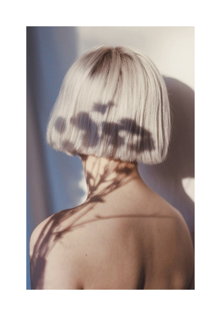 The back of a bare shouldered woman with a white page.