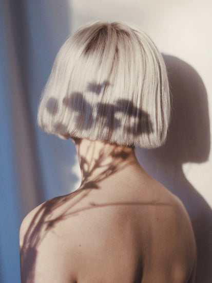 The back of a bare shouldered woman with a white page.