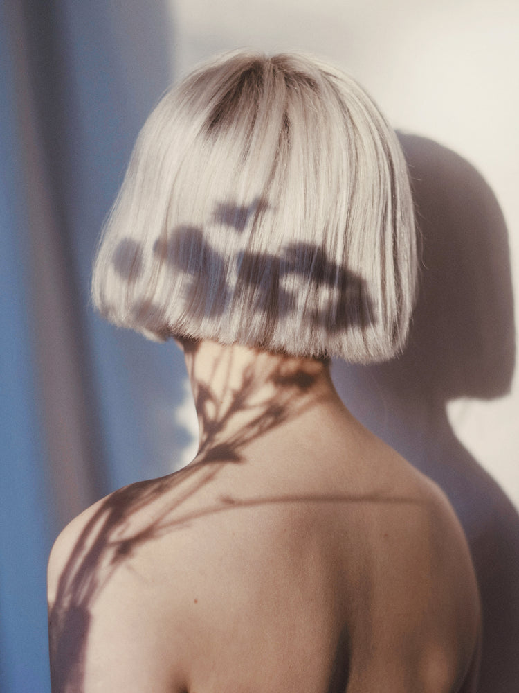 The back of a bare shouldered woman with a white page.