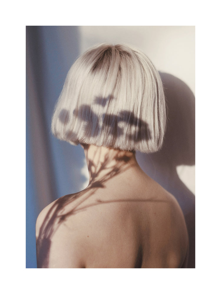 The back of a bare shouldered woman with a white page.