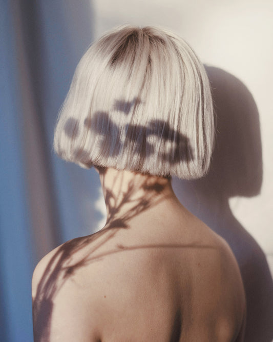 The back of a bare shouldered woman with a white page.