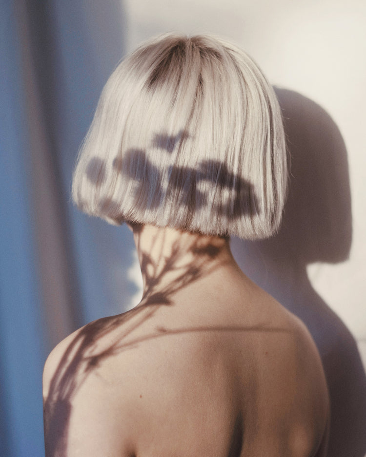 The back of a bare shouldered woman with a white page.