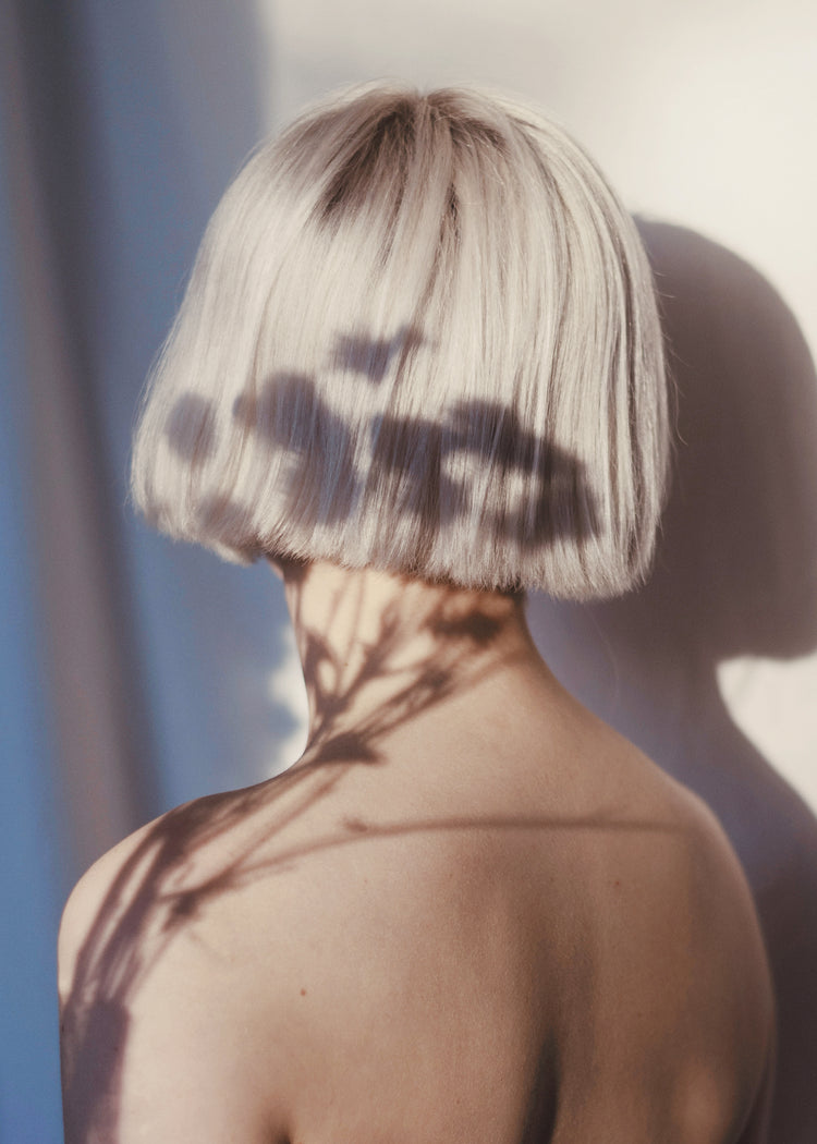 The back of a bare shouldered woman with a white page.