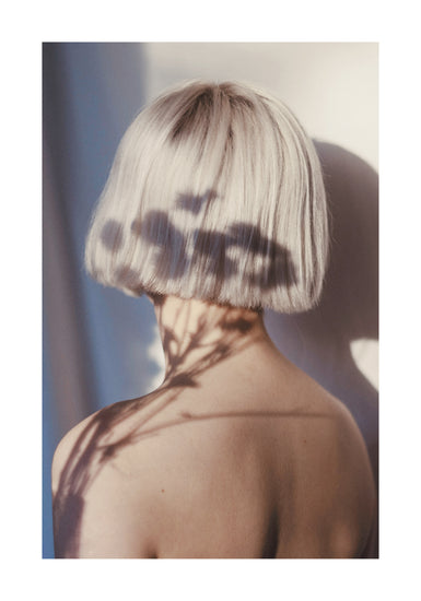 The back of a bare shouldered woman with a white page.