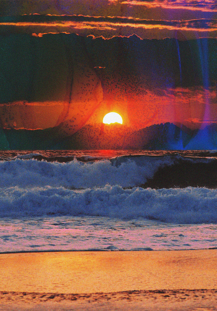 Waves crashing on the shore illuminated by a golden sunset on a cloudy sky.