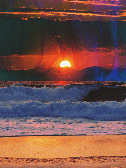 Waves crashing on the shore illuminated by a golden sunset on a cloudy sky.