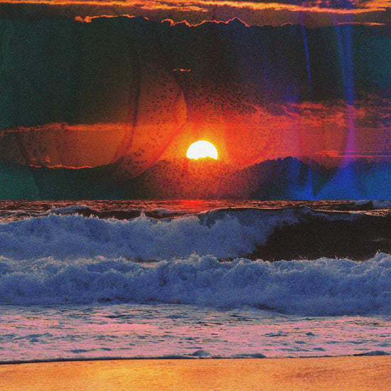 Waves crashing on the shore illuminated by a golden sunset on a cloudy sky.