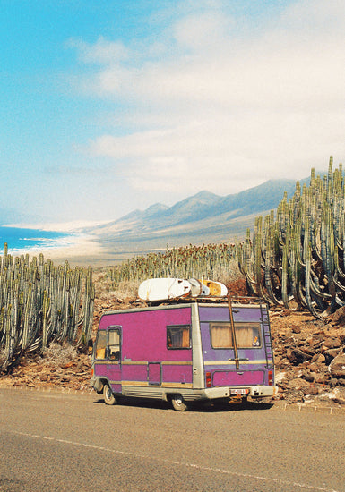 Pink trailer on the road through the dessert towards the ocean coast.