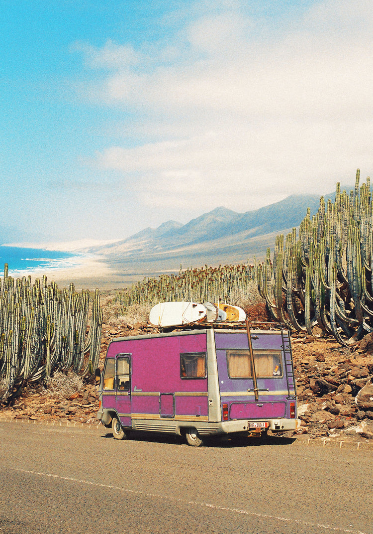 Pink trailer on the road through the dessert towards the ocean coast.