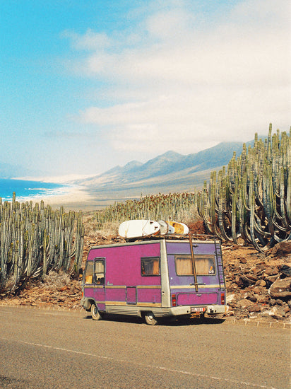 Pink trailer on the road through the dessert towards the ocean coast.