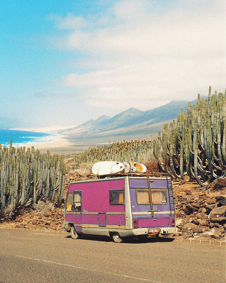 Pink trailer on the road through the dessert towards the ocean coast.