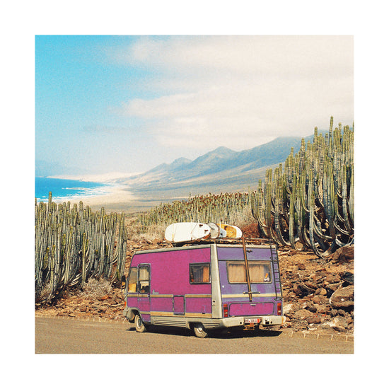 Pink trailer on the road through the dessert towards the ocean coast.